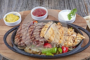 Combo Fajita; top down photo of mexican steak and chicken fajitas in iron skillet with corn tortillas