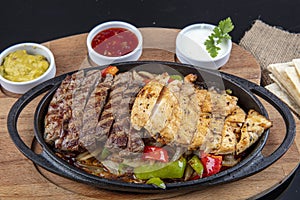 Combo Fajita; top down photo of mexican steak and chicken fajitas in iron skillet with corn tortillas