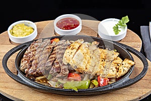 Combo Fajita; top down photo of mexican steak and chicken fajitas in iron skillet with corn tortillas