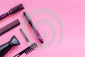 Combs, dryer and hairdresser tools in beauty salon work desk on pink background top view mockup