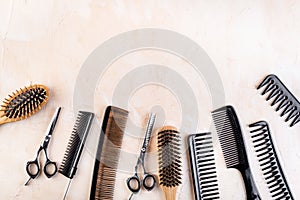 Combs, hairbrush, scissors - hairdresser eqiupment - on beige table top-down space for text