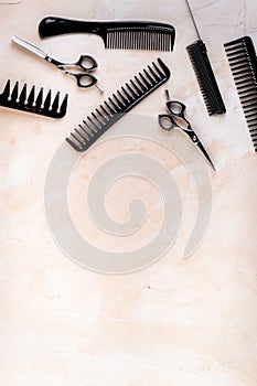 Combs, hairbrush, scissors - hairdresser eqiupment - on beige table top-down space for text