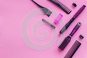 Combs and hairdresser tools in beauty salon work desk on pink background top view mockup