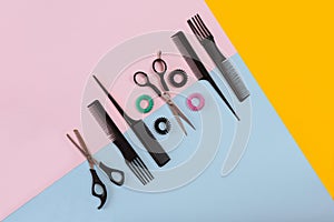 Combs and hairdresser tools on color background top view