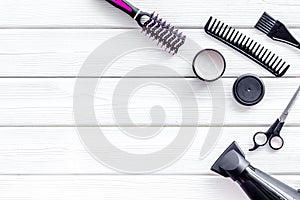 Combs, sciccors and pink hairdresser tools in beauty salon work desk on white wooden background top view mockup