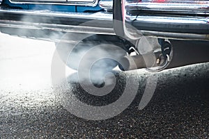 Combustion fumes coming out of car exhaust pipe