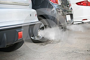 Combustion fumes coming out of car exhaust pipe photo