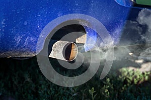 Combustion fumes coming out of car exhaust pipe