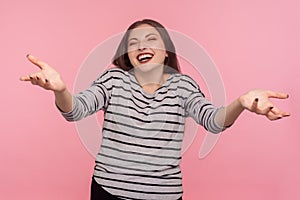 Come and give me hug. Portrait of cheerful friendly young woman in striped sweatshirt keeping hands open