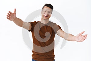 Come here my dear friend. Portrait of hospitable, friendly smiling adult man reaching hands for hug, embrace person as