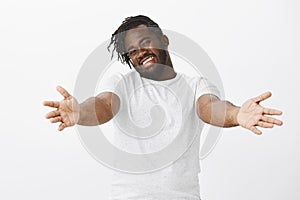 Come I want hugs. Friendly loving plump african man with beard, stretching hands towards camera to cuddle, smiling