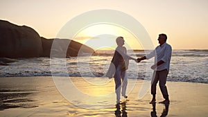 Come on, lets dance. Full length shot of an affectionate senior couple dancing together at the beach at sunset.