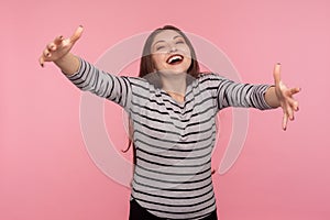 Come into my arms! Portrait of hospitable excited friendly woman in striped sweatshirt raising hands to embrace