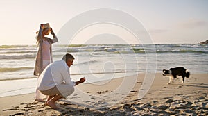 Come on now. Full length shot of an affectionate senior couple playing with their dog at the beach.