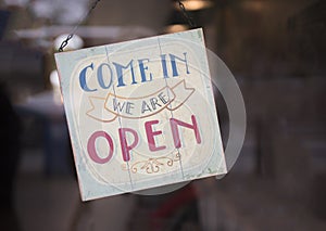 Come in we are open sign in a shop window