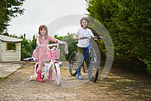 Come ride with us. Portrait of two little siblings riding their bikes together outdoors.