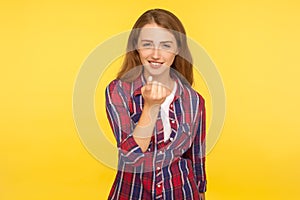 Come to me! Portrait of smiling positive ginger girl in checkered shirt making beckoning gesture with finger