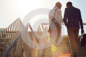 They come up with the best ideas when travelling together. Low angle shot of unrecognizable businessmen walking up