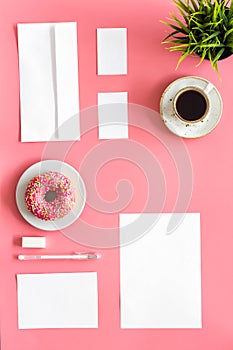 Come up with brand identity. Blank stationery for branding near coffee and donut on pink background top view mockup