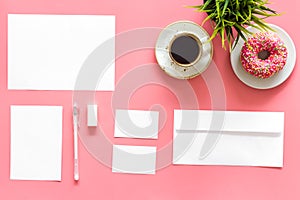 Come up with brand identity. Blank stationery for branding near coffee and donut on pink background top view mockup