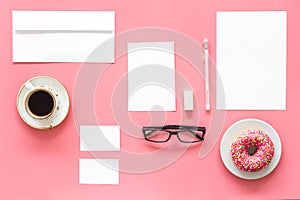 Come up with brand identity. Blank stationery for branding near coffee and donut on pink background top view mockup