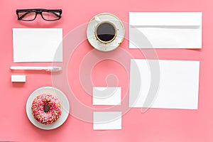 Come up with brand identity. Blank stationery for branding near coffee and donut on pink background top view mockup