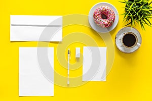 Come up with brand identity. Blank stationery for branding near coffee and donut on yellow background top view mockup