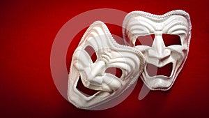 Comedy and Tragedy theatrical mask isolated on a red background and copy space