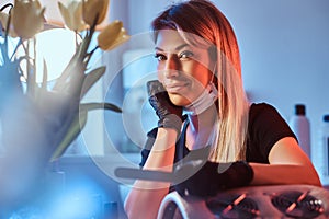 Comely female manicurist is smiling to the camera