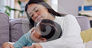 Comfort, care and mother hugging her child on a sofa in the living room of family house. Sad, depression and Asian mom