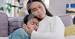 Comfort, love and mother hugging her child on a sofa in the living room of family house. Sad, depression and Asian mom