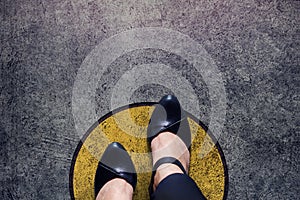 Comfort zone concept, woman with leather shoes steps over circle photo