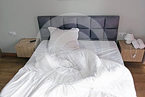 Comfortable bed with white linen at home.