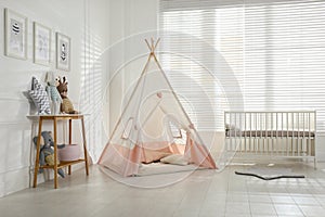 Comfortable crib and play tent in baby room. Interior design