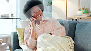 Comfortable at home on a couch talking on the phone with a best friend. A young African woman relaxing on a sofa