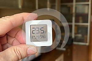 Comfortable humidity and temperature in the apartment. Close-up of a man's hand holding a hygrometer and thermometer