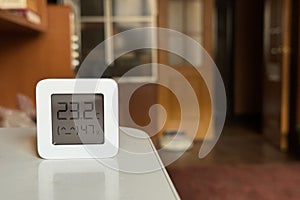 Comfortable humidity and temperature in the apartment. White hygrometer on the table