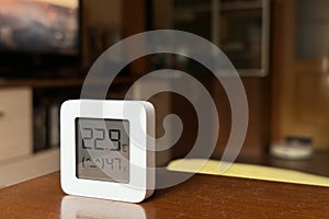 Comfortable humidity and temperature in the apartment. White hygrometer on the table