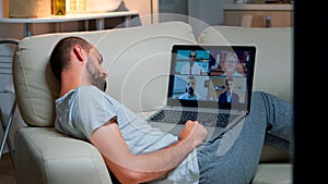 Comfortable man in pajamas falling asleep while chatting with collegues