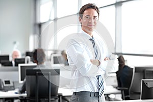 Comfortable in my workplace. Young business executive standing in the office looking confident - portrait.