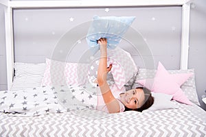 Comfortable pillow. Girl smiling child lay bed star pattern pillows and plaid bedroom. Bedclothes for children. Girl kid