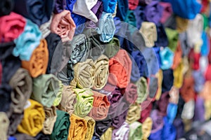 Rolls of vibrant colorful tshirts stacked in a store, comfortable seasonal clothing photo