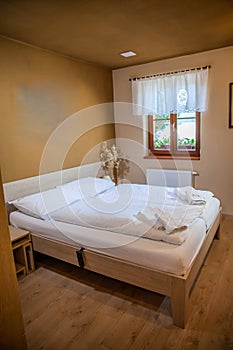Comfortable rustic hotel room with white bed linen at a nature park