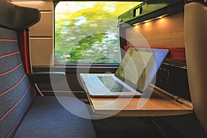 Comfortable seat in first class with laptop on train compartment