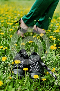 Comfortable shoes concept. Business woman changing shoes Work Heels from high heel to comfortable sneakers on green grass