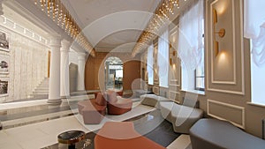 Comfortable sofas fairy lights and columns in palace hallway