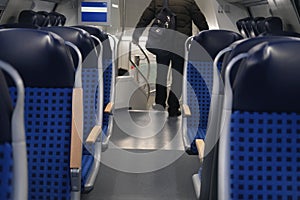 Comfortable soft blue seats with headrests in half-empty train car in Germany, concept of long-distance travel, ticket for