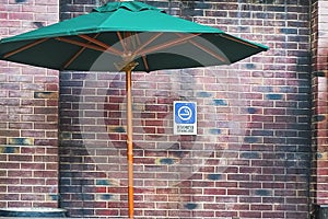 Comfortable sunshade and permitted information signage for smokers