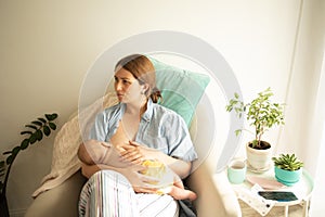 Comfortable and tranquil breastfeeding in cosy armchair at home
