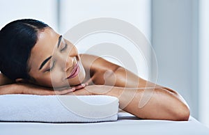 Comfortable is an understatement. a relaxed an cheerful young woman getting a massage indoors at a spa.